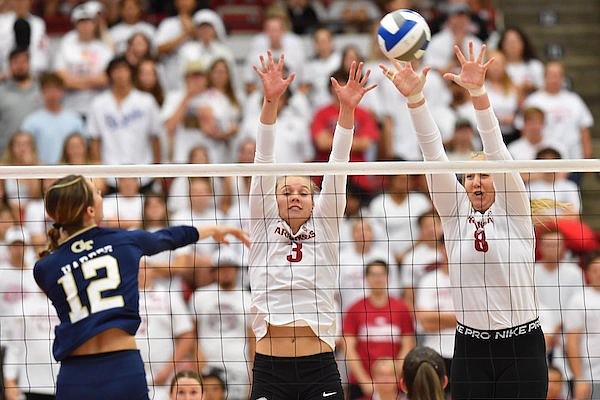 Georgia Tech's Leia Harper (12) sends the ball over the net Thursday, Sept. 15, 2022, as Arkansas' Hailey Dirrigl (3) and Tatum Shipes (8) defend during play in Barnhill Arena on the university campus in Fayetteville.