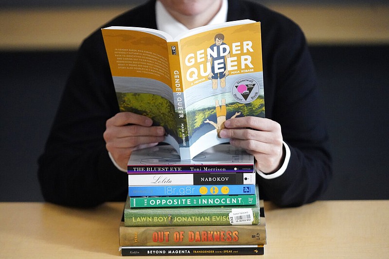 FILE - Amanda Darrow, director of youth, family and education programs at the Utah Pride Center, poses with books that have been the subject of complaints from parents in Salt Lake City on Dec. 16, 2021.  The wave of attempted book banning and restrictions continues to intensify, the American Library Association reported Friday. Numbers for 2022 already approach last year's totals, which were the highest in decades. (AP Photo/Rick Bowmer, File)