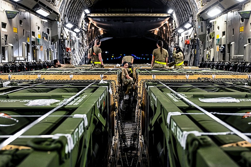 Airmen load Guided Multiple Launch Rocket System munitionsfrom Lockheed Martin’s plant outside Camden bound for Ukraine aboard a Boeing 767 at Joint Base McGuire-Dix-Lakehurst, N.J., on Aug. 13. In late August, the company received $600 million from defense officials for replenishing stockpiles of the multiple rocket and HIMARs systems. 
(Special to the Democrat-Gazette)