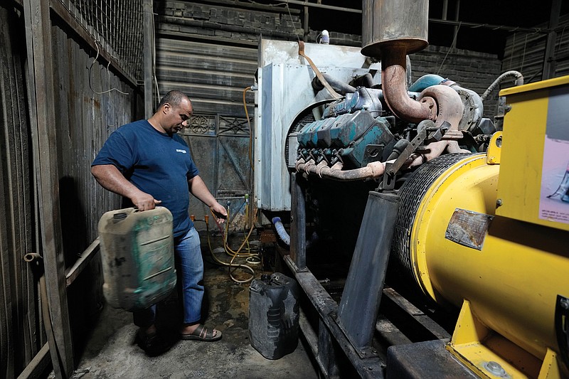Saad Haider fuels a generator in July to provide electricity to private homes in Baghdad.
(AP/Hadi Mizban)