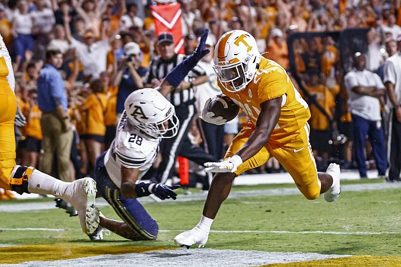 Tennessee running back Dylan Sampson (24) crosses the goal line in front of Akron cornerback Tyson Durant (28) during the first half of an NCAA college football game, Saturday, Sept. 17, 2022, in Knoxville, Tenn. (AP Photo/Wade Payne)