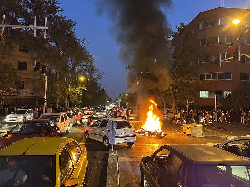 In this Monday, Sept. 19, 2022, photo taken by an individual not employed by the Associated Press and obtained by the AP outside Iran, a police motorcycle is burning during a protest over the death of a young woman who had been detained for violating the country's conservative dress code, in downtown Tehran, Iran. (AP Photo)