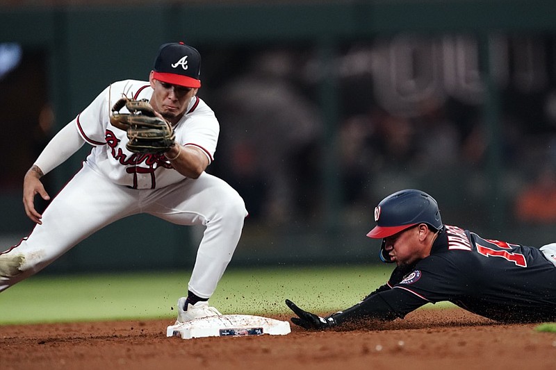 Washington Nationals' Ildemaro Vargas, right, beats a tag by Atlanta Braves second baseman Vaughn Grissom, left, after hitting a double in the fifth inning of a baseball game Monday, Sept. 19, 2022, in Atlanta. (AP Photo/John Bazemore)