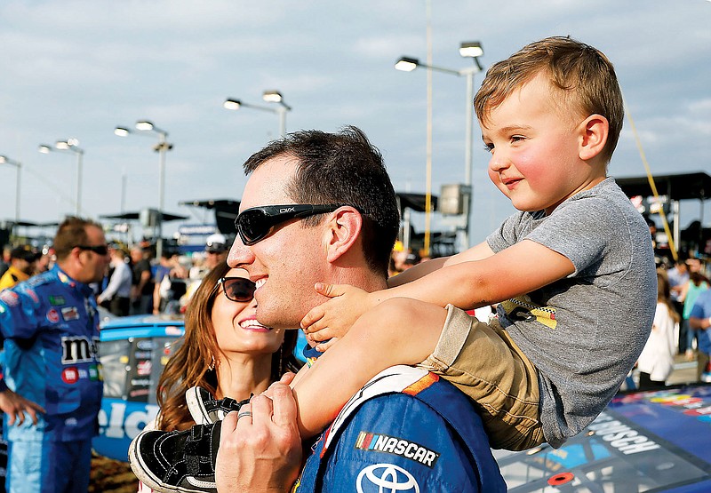 In this May 12, 2018, file photo, Kyle Busch carries his son, Brexton, as his wife Samantha watches before the NASCAR Cup Series race at Kansas Speedway in Kansas City, Kan. (Associated Press)