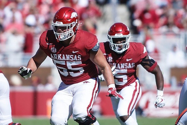 Arkansas running back Raheim Sanders (5) carries the ball behind Arkansas offensive lineman Beaux Limmer (55) on Saturday, Oct. 16, 2021, during the first half of play at Reynolds Razorback Stadium in Fayetteville.