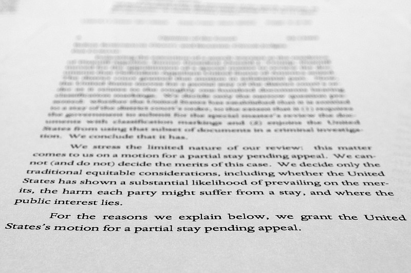 A page from a U.S. Court of Appeals for the 11th Circuit in Atlanta ruling that lifts a judge's hold on the Justice Department's ability to use classified documents seized by the FBI at Trump's Mar-a-Lago estate, is photographed Wednesday, Sept. 21, 2022. The ruling clears the way for the department to immediately resume its use of the documents in its investigation.(AP Photo/Jon Elswick)