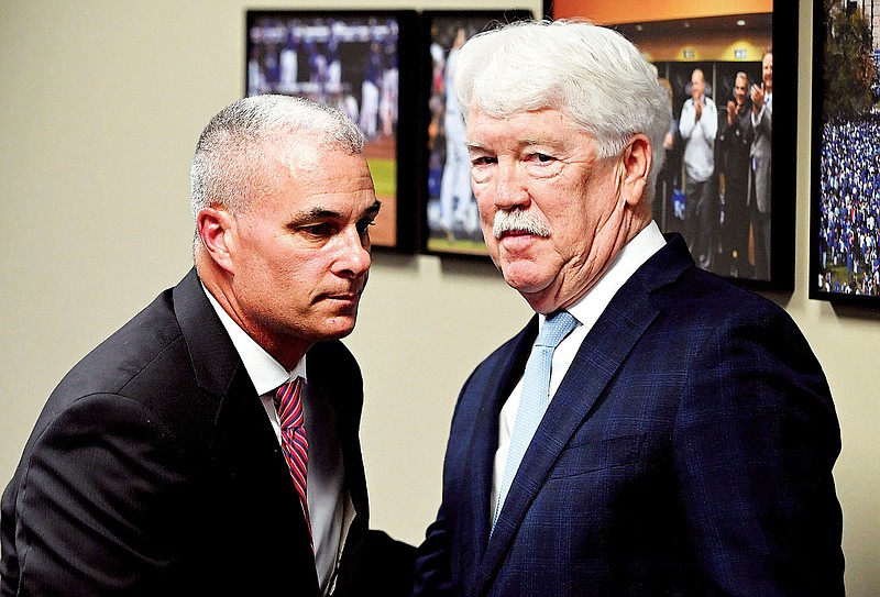 Royals chairman and CEO John Sherman (right) looks away as Dayton Moore walks behind him during a news conference Wednesday at Kauffman Stadium in Kansas City. (The Kansas City Star via the Associated Press)