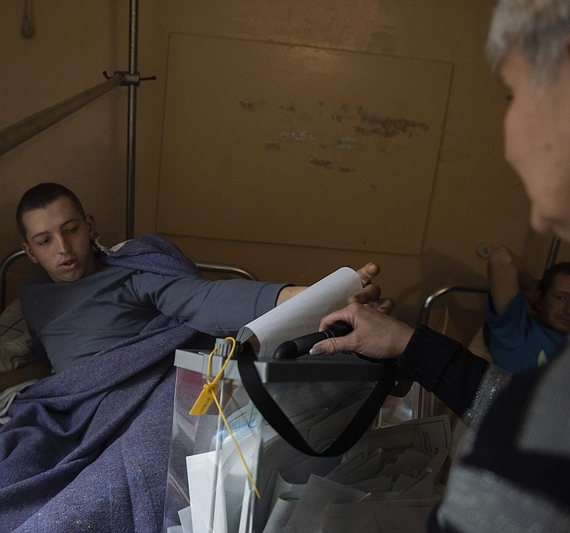 A wounded Luhansk People’s Republic serviceman votes Friday in a hospital in Luhansk in eastern Ukraine in a sector controlled by Russian-backed separatists. More photos at arkansasonline.com/ukrainemonth7/.
(AP)