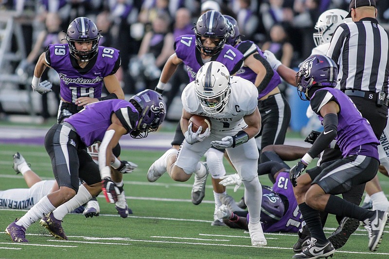 Bentonville West’s Carson Morgan (center) gains yardage as Fayetteville’s Deuce Cooper and CJ Williams close in to tackle Friday at Harmon Stadium in Fayetteville. 
(Special to NWA Democrat-Gazette/Brent Soule)