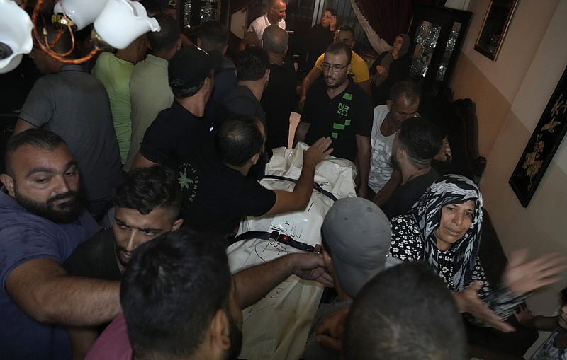 Mourners gather around a covered dead body, one of several victims who were on a boat carrying migrants from Lebanon that sank Friday in Syrian waters.
(AP/Bilal Hussein)