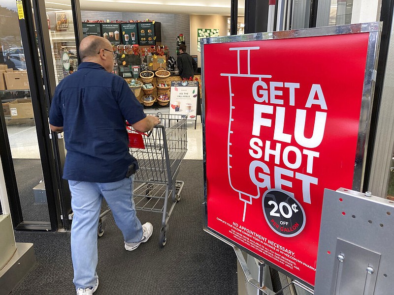 A shopper passes a sign urging people to get a flu shot outside a Hy-Vee grocery store in Sioux City, Iowa, in this Oct. 6, 2021 file photo. (AP/David Zalubowski)