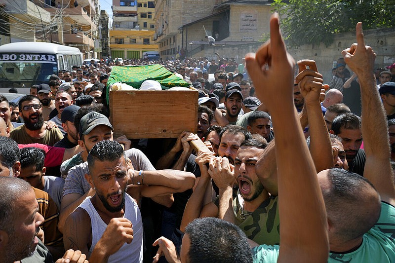 Mourners chant slogans as they carry the coffin of Palestinian Abdul-Al Omar Abdul-Al, 24, who was on a boat carrying migrants from Lebanon that sank in Syrian waters, during his funeral processions, in the Palestinian refugee camp of Nahr el-Bared near the northern city of Tripoli, Lebanon, Saturday, Sept. 24, 2022. (AP/Bilal Hussein)