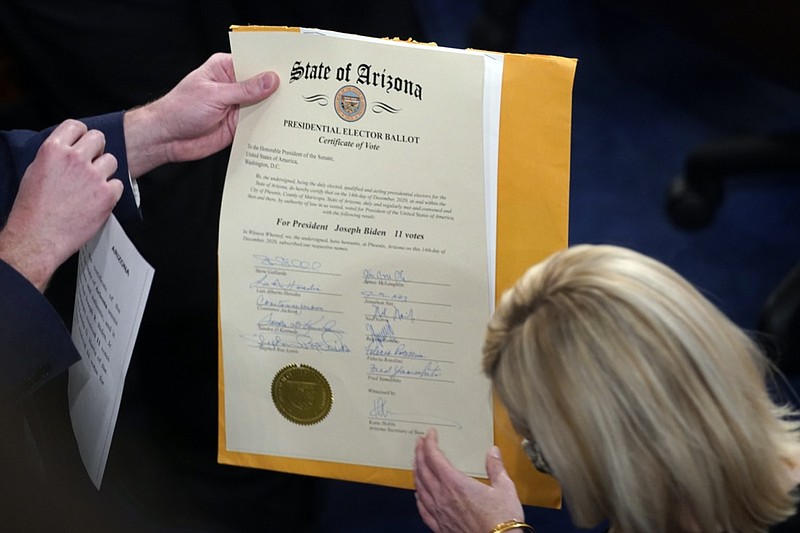 FILE - The certification of Electoral College votes for the state of Arizona is unsealed during a joint session of the House and Senate convenes to confirm the electoral votes cast in November's election, at the Capitol, Jan 6, 2021. Members of Congress have officially objected to the results in four of the last six presidential elections, a partisan practice that has been legal for over a century but became much more fraught after a violent mob of former President Donald Trump’s supporters attacked the Capitol last year. (AP Photo/Andrew Harnik, File)