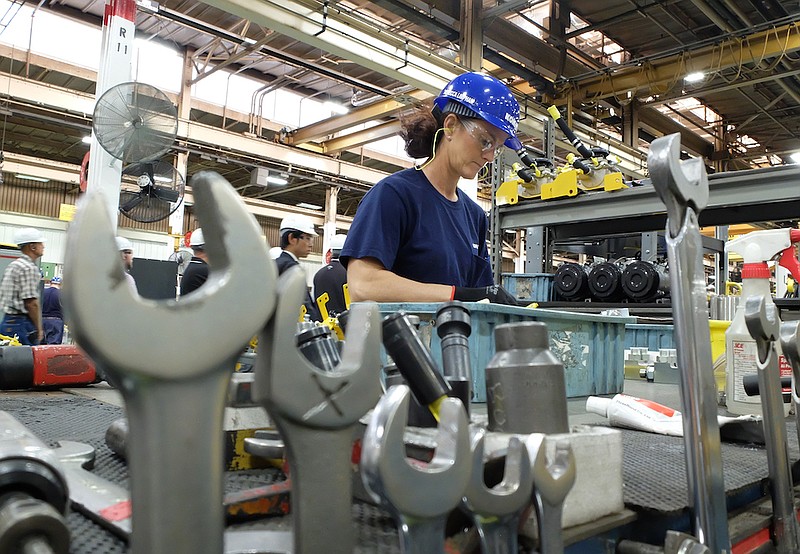 Staff file photo / Rebecca Limpham works at her station inside Chattanooga's Komatsu America Corp. assembly plant in Chattanooga.