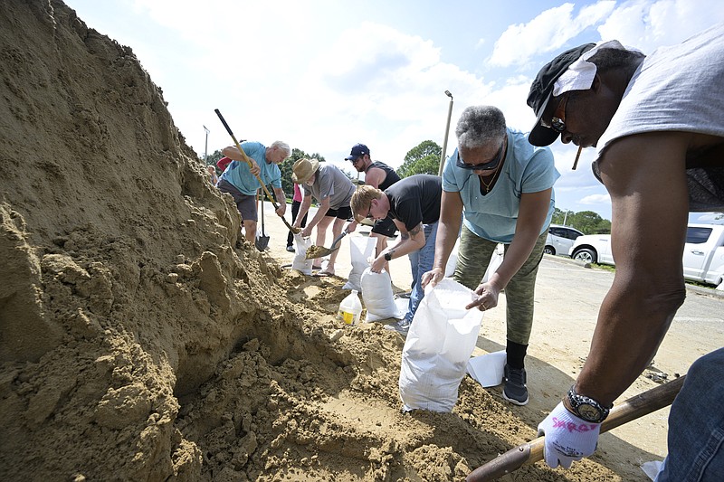 Johnny Ford, right, and his wife Jerria Ford fill free sand bags at an Orange County park in preparation for the arrival of Hurricane Ian, Monday, Sept. 26, 2022, in Orlando, Fla. (AP Photo/Phelan M. Ebenhack)