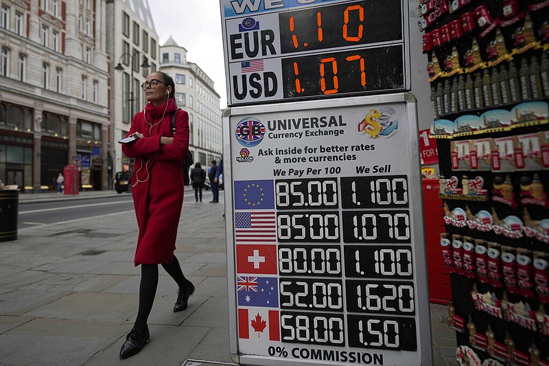 A woman walks past a sign that shows the exchange rate at a bureau de change in London, Tuesday, Sept. 27, 2022. (AP/Frank Augstein)