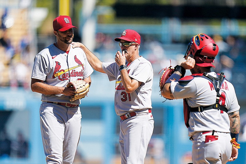 Cardinals starting pitcher Adam Wainwright is visited by pitching coach Mike Maddux during the first inning of Sunday afternoon’s game against the Dodgers at Dodger Stadium in Los Angeles. (Associated Press)