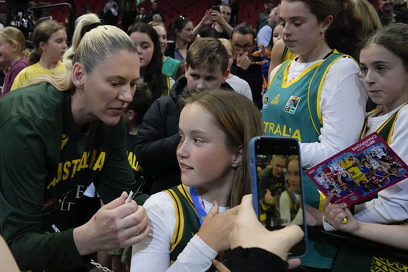 Australian basketball star Lauren Jackson (left) signs autographs for fans after Australia’s win over Japan at the women’s World Cup on Tuesday at Sydney.
(AP/Mark Baker)