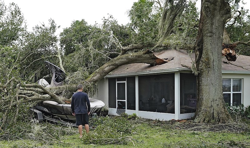 People survey damage to their home in the aftermath of Hurricane Ian, Thursday, Sept. 29, 2022, in Valrico, Fla. (AP Photo/Chris O'Meara)