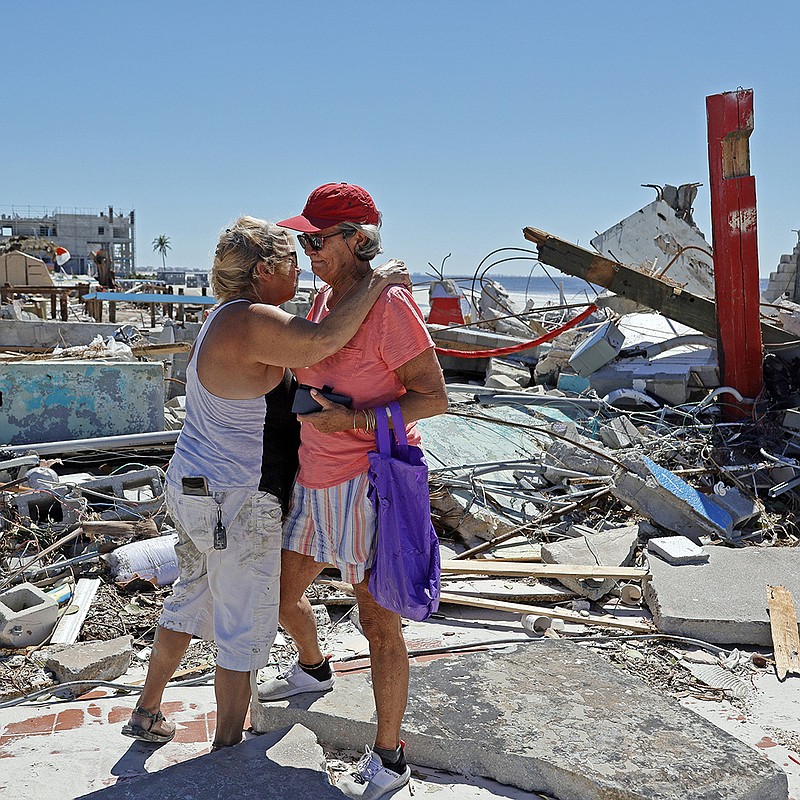 Local muralist Candy Miller (left) embraces Ana Kapel, the manager of the Pier Peddler, a gift shop that sold women’s fashions, as she becomes emotional Friday at the site of what used to be the store on the island of Fort Myers Beach, Fla. More photos at arkansasonline.com/101ian/.
(AP/South Florida Sun-Sentinel/Amy Beth Bennett)