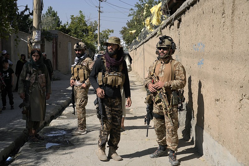 Taliban fighters stand guard in front of an education center that was attacked Friday by a suicide bomber in Kabul, Afghanistan.
(AP/Ebrahim Noroozi)