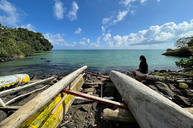 Eseta Vusamu sits near the water Thursday, Sept. 29, 2022, in the village of Faleasiu on the island of Upolu in Samoa. When and if an island nation fully submerges due to climate change, what happens to the nationalities of its citizens? “If you ask our people to move, there is no way we would voluntarily leave,” Vusamu said. (AP Photo/Lagipoiva Cherelle Jackson)