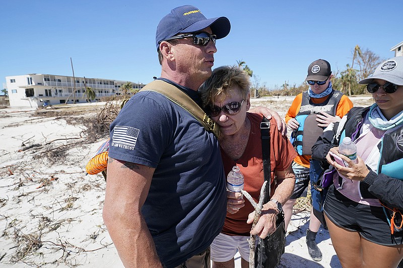 Resident Judy Hicks is embraced Friday by rescuer Bryon Wheeldon before she is taken off Sanibel Island, Fla., following Hurricane Ian.
(AP/Steve Helber)