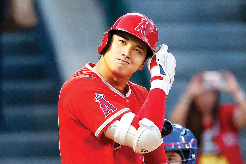 Shohei Ohtani of the Angels checks his batting helmet during his at-bat in the first inning of Saturday's game against the Rangers in Anaheim, Calif. (Associated Press)