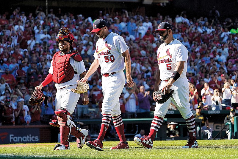 Cardinals catcher Yadier Molina, starting pitcher Adam Wainwright and first baseman Albert Pujols walk off the field together as they are removed at the same time in the fifth inning of Sunday’s game against the Pirates at Busch Stadium in St. Louis. (Associated Press)