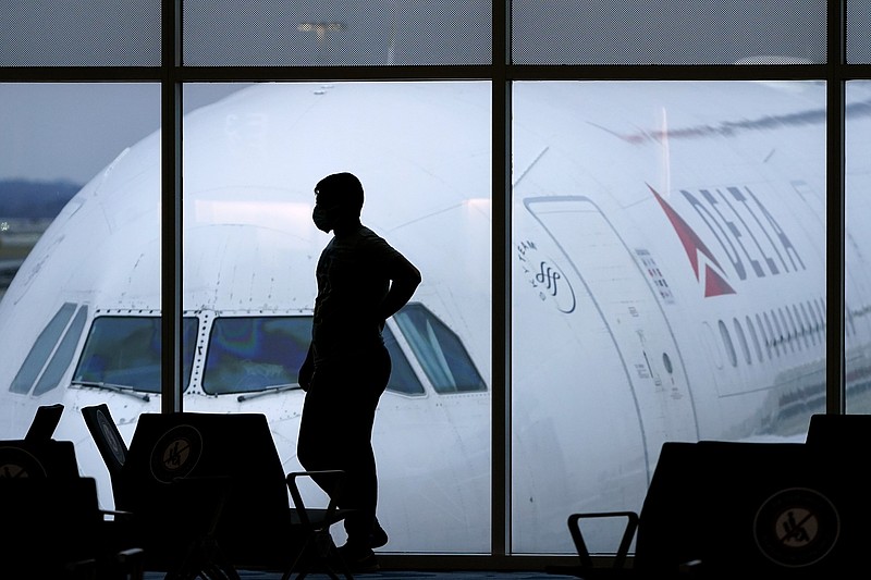 A passenger wears a face mask as he waits for a Delta Airlines flight at Hartsfield-Jackson International Airport in Atlanta on Feb. 18, 2021. (AP Photo/Charlie Riedel, File)
