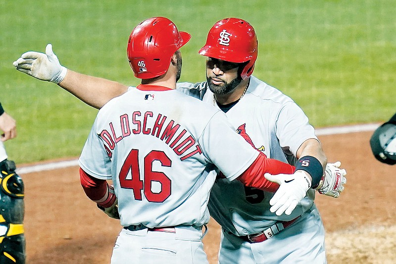 Albert Pujols celebrates with Cardinals teammate Paul Goldschmidt after he hit career home run No. 703 in the fifth inning of Monday night’s game against the Pirates in Pittsburgh. (Associated Press)