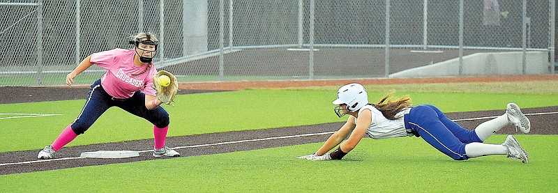 Kylie Baker of Capital City dives toward third base as Helias third baseman Alex Wilde waits for throw during the sixth inning of Monday night’s game at Capital City High School. (Shaun Zimmerman/News Tribune)
