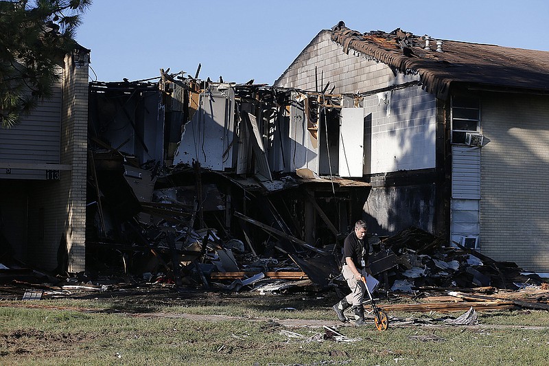 North Little Rock Police detective John Desizlets takes measurements while investigating an early morning fire at Shorter College Garden Apartments that killed three people on Tuesday, Oct. 4, 2022, in North Little Rock. .(Arkansas Democrat-Gazette/Thomas Metthe)