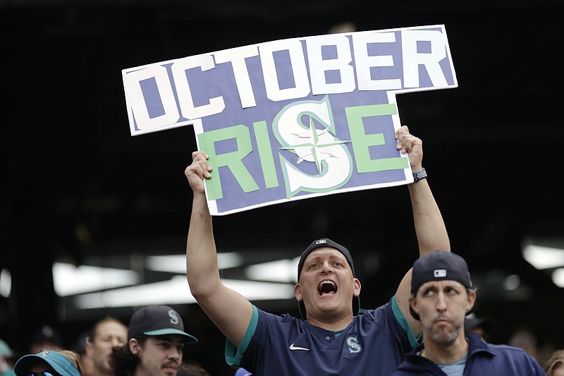 A Seattle Mariners fan holds a sign reflecting the Mariners’ return to baseball’s postseason for the first time since 2001. The wildcard series begins Friday with a full slate of four games.
(AP/John Froschauer)