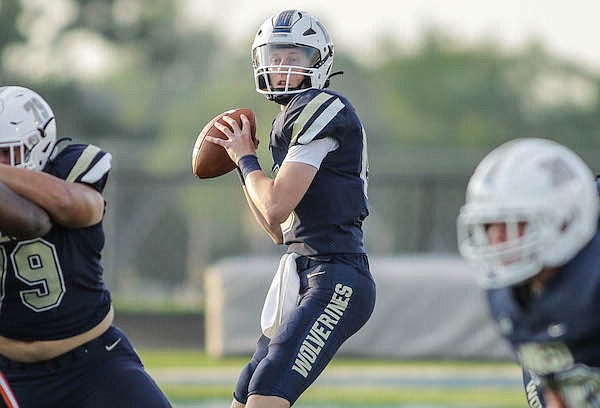 Bentonville West Wolverines Junior Jake Casey (15) drops back to pass during the Booker T. Washington Hornets vs. Bentonville West Wolverines game Friday night, August 26, 2022, at Bentoville West Wolverines Stadium in Centerton.