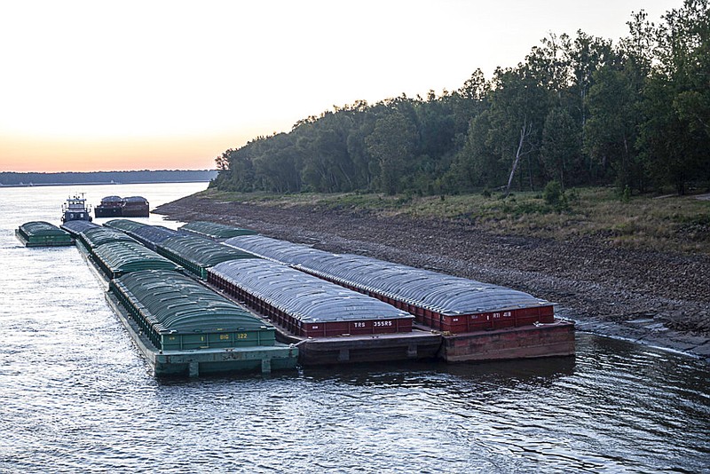 Barges idle while waiting for passage in the Mississippi River near Vicksburg, Miss., on Tuesday, Oct. 4, 2022. The unusually low water level in the lower Mississippi River is causing barges to get stuck in the muddy river bottom, resulting in delays. (Thomas Berner via AP)