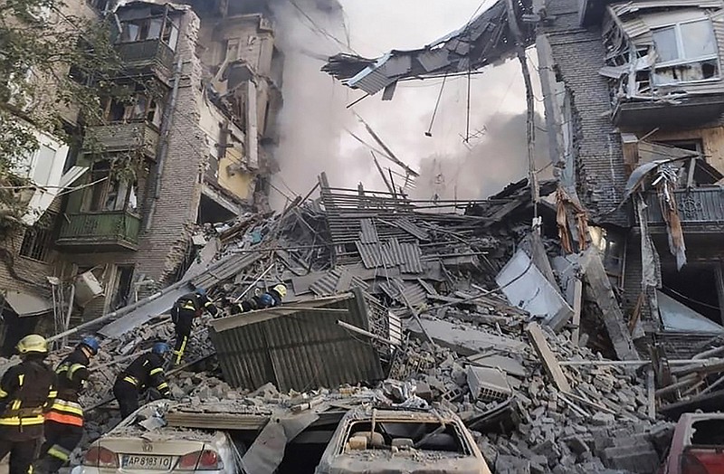 Rescuers work at a destroyed building Thursday in Zaporizhzhia, Ukraine, after Russian missiles damaged more than 40 buildings. Officials said more than 20 people were rescued, but at least seven more were killed. More photos at arkansasonline.com/ukrainemonth8/.
(AP/Ukrainian Emergency Service)