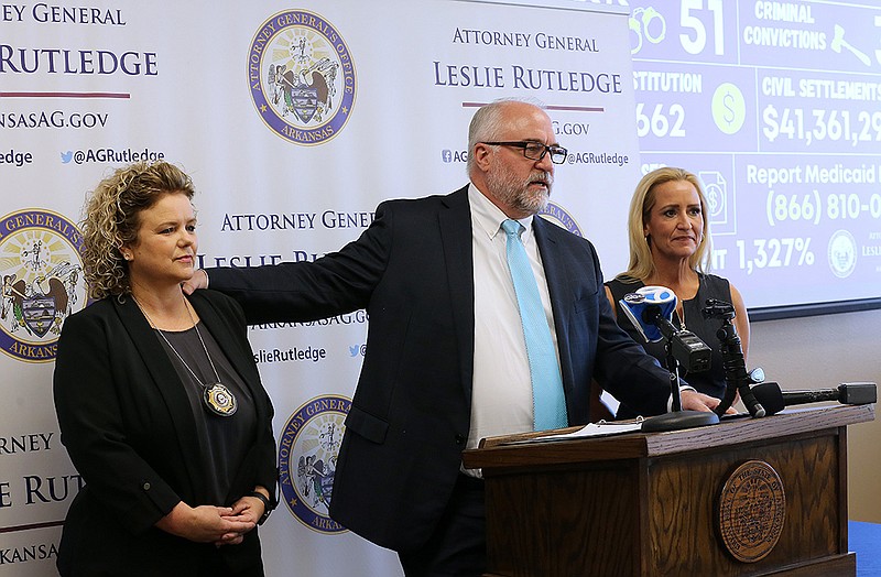Deputy Attorney General Lloyd Warford (center), director of the Medicaid Fraud Control Unit, talks about the work done by Special Agent Rhonda Swindle (left) and others on the staff in making fiscal 2022 a record-breaking year for arrests, convictions and civil settlements during a news conference as Attorney General Leslie Rutledge listens on Thursday in Little Rock.
(Arkansas Democrat-Gazette/Thomas Metthe)