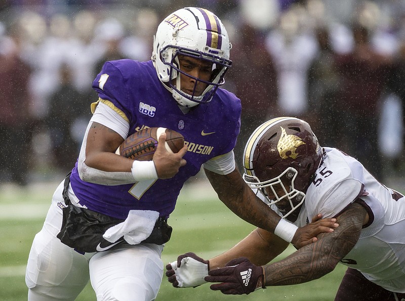 James Madison quarterback Todd Centeio (left) fights off Texas State linebacker Sione Tupou as he runs for a touchdown in the Duke’s 40-13 victory over the Bobcats on Oct. 1 at Harrisonburg, Va. Arkansas State hosts James Madison on Saturday looking to hand the Dukes their first loss of the season.
(AP/Daily News-Record/Daniel Lin)