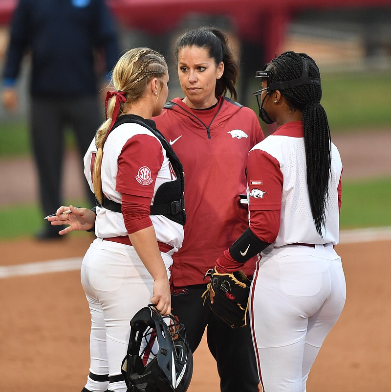 Arkansas coach Courtney Deifel speaks to catcher Taylor Ellsworth and pitcher Chenise Delce Thursday, May 26, 2022, during the fifth inning of the Razorbacks? 7-1 win over Texas in the Fayetteville Super Regional at Bogle Park in Fayetteville. 
(NWA Democrat-Gazette/Andy Shupe)