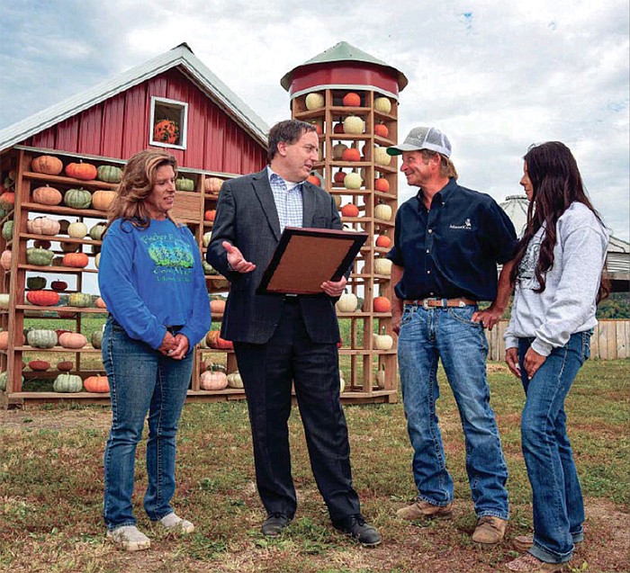 Missouri Secretary of State Jay Ashcroft holds a proclamation as he reads it to Fischer Farms’ owners during a visit to the north Jefferson City farm Wednesday, Oct. 5, 2022. Kim Fischer, left, was joined by her husband, Jay, and her daughter, Jenna, for the event. (Julie Smith/News Tribune photo)