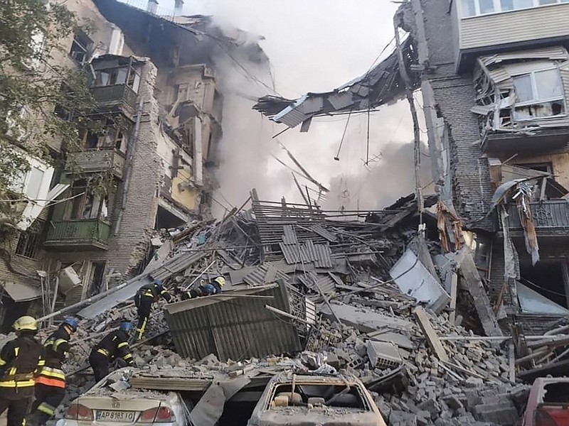 In this photo provided by the Ukrainian Emergency Service, rescuers work at the scene of a building damaged by shelling in Zaporizhzhia, Ukraine, Thursday, Oct. 6, 2022. (Ukrainian Emergency Service via AP Photo)