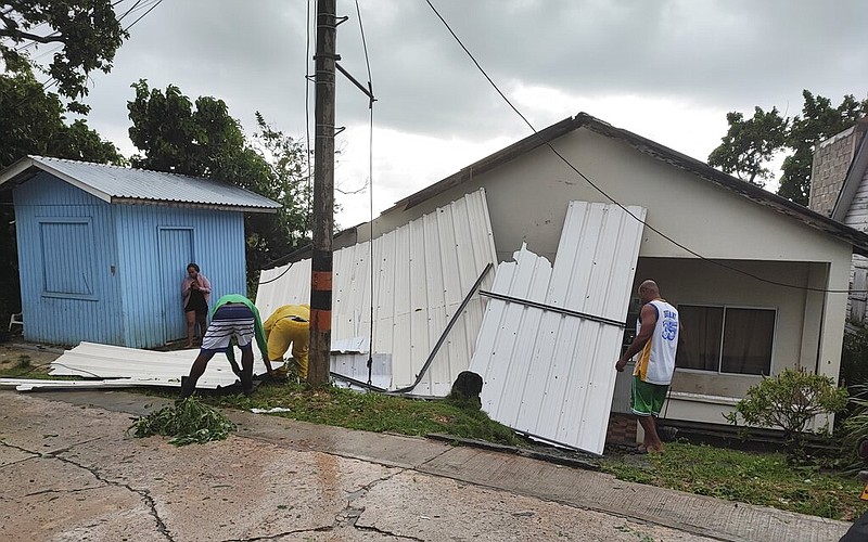 Men pick up a damaged roof in the aftermath of Hurricane Julia in San Andres island, Colombia, Sunday, Oct.9, 2022. (AP/Daniel Parra)