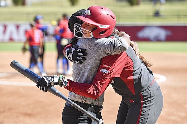 Arkansas third baseman Spencer Prigge hugs an assistant coach after hitting a home run during an exhibition game against Louisiana Tech on Sunday, Oct. 9, 2022, in Fayetteville.