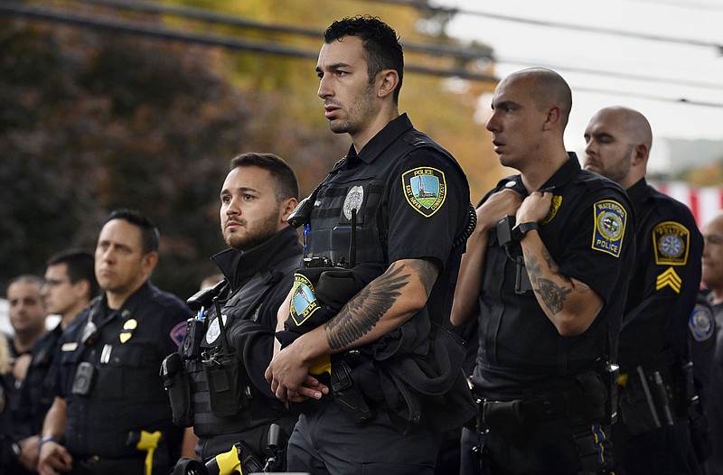 Police officers from towns across Connecticut stand at the scene in Bristol, Conn., where two police officers were killed on Thursday after being lured to a house by a 911 call.
(AP/Jessica Hill)