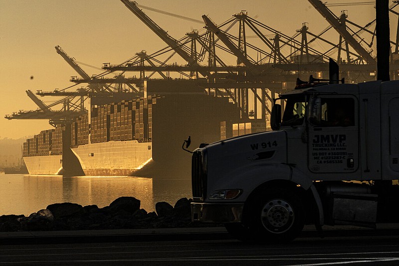 FILE - A truck arrives to pick up a shipping container near vessels at the Port of Los Angeles, on Nov. 30, 2021. (AP/Damian Dovarganes, File)