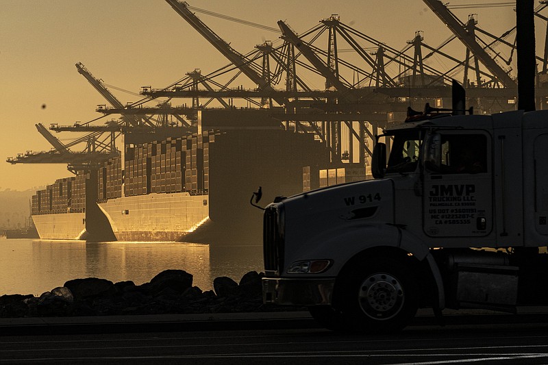 A truck arrives to pick up a shipping container near vessels at the Port of Los Angeles, on Nov. 30, 2021. (AP Photo/Damian Dovarganes, File)