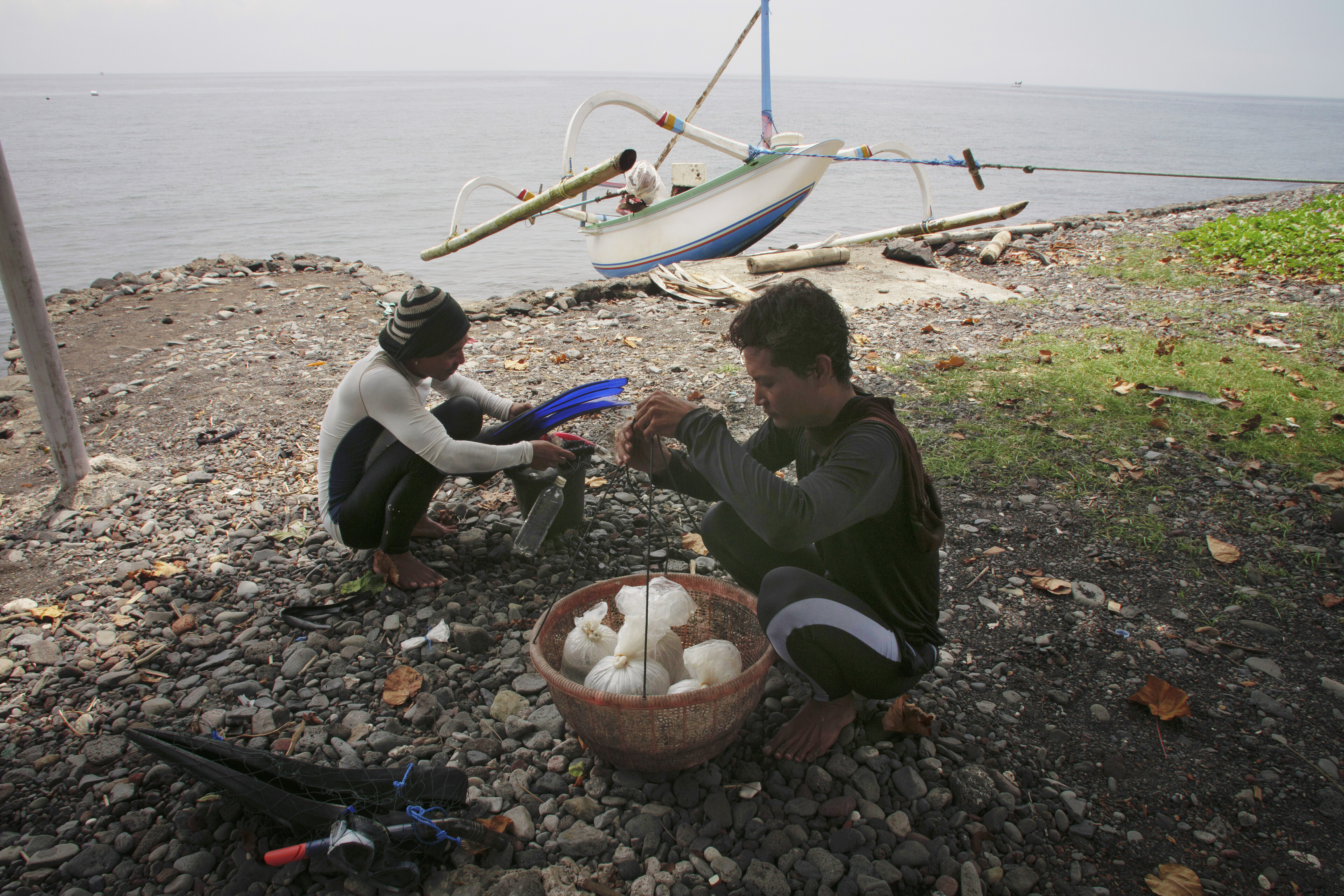 Made Partiana and another villager sort fish caught during the day on April 11, 2021. â€œI hope that [healthier] coral reefs will make it possible for the next generation of children and grandchildren under me,â€ Partiana says. He wants them to be able to â€œsee what coral looks like and that there can be ornamental fish in the sea.â€ (AP Photo/Alex Lindbloom)