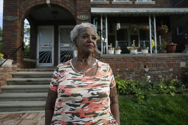Pamela Jackson-Walters stands outside her home Wednesday, Sept. 21, 2022, in Detroit. Jackson-Walters uses her home internet connection to attend church services virtually and to pursue a graduate degree, but the service AT&T offers in her mostly Black neighborhood is much slower than in other parts of the city. She said she also experienced an internet outage for four weeks during the summer.(AP Photo/Paul Sancya)