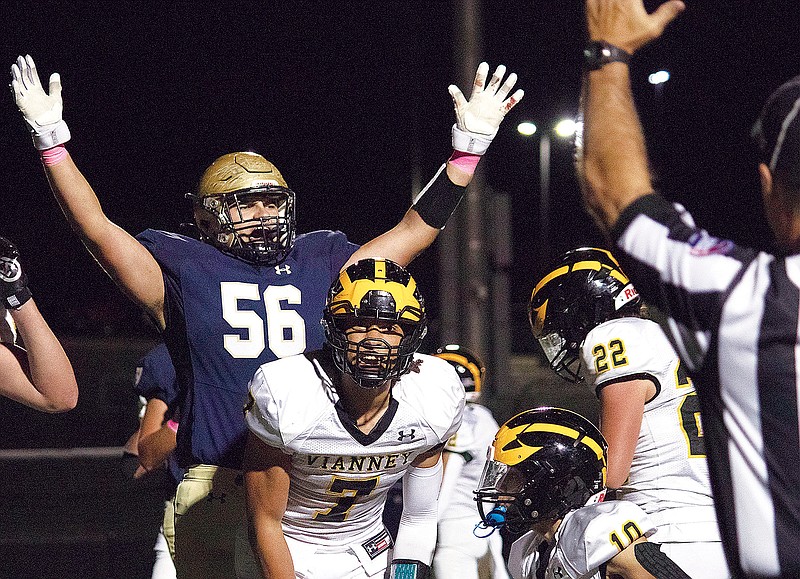 Helias offensive lineman Jace West signals touchdown as Vianney defensive end Braxton Pritchett reacts to a referee signaling a score during the first half of Friday night’s game at Ray Hentges Stadium. (Kate Cassady/News Tribune)